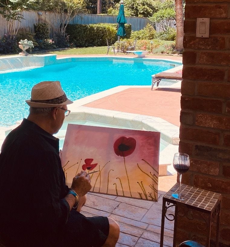 A photo of Benny Agosto Jr. painting on a canvas